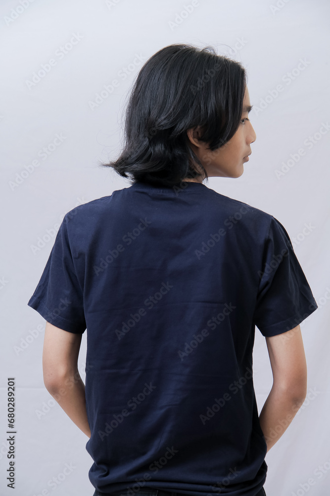 Clothing model. Young Asian man with long curly hair close up shot isolated on white. Asian young man wearing navy blue t-shirt isolated on white background. As if he were modeling a plain t-shirt. Clothing model. Young Asian man with long curly hair close up shot isolated on white. Asian young man wearing navy blue t-shirt isolated on white background. As if he were modeling a plain t-shirt.