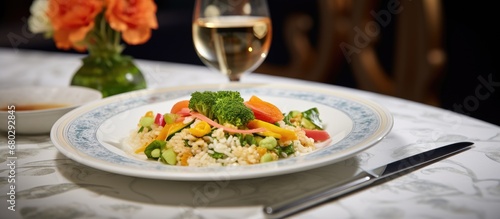 At the white table of the elegant restaurant  a delectable Asian salad with fresh vegetables  cheese  and rice was served on a Chinese porcelain plate  accentuated by a stone upon which the delectable