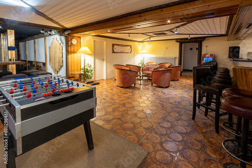 Cozy basement bar room with games and seating photo