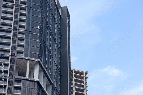 high rise building with concrete frame  building under construction facing bright blue sky.  multi-storey residential building  stylish building  modern architectural style.  Banner  space for text.