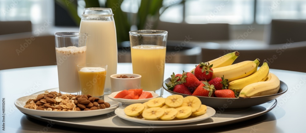On the table, a healthy breakfast spread awaited, featuring an array of nutrient-rich foods such as yogurt, fruit, organic chocolate, and a glass of refreshing juice made with natural ingredients On the table, a healthy breakfast spread awaited, featuring an array of nutrient-rich foods such as yogurt, fruit, organic chocolate, and a glass of refreshing juice made with natural ingredients