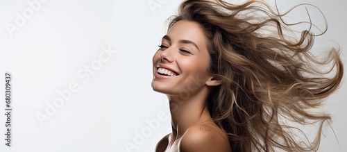 The young woman, with a happy smile on her beautiful face, poses against a white background, exuding confidence and radiating beauty, captivating people with her fashionable style and stunning hair, a
