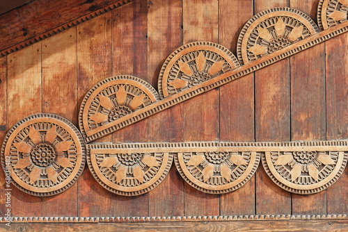 Artistic folk woodwork sin the shape of sunstars on the wood gable of a building in the Old Bazaar. Kruje-Albania-059 photo