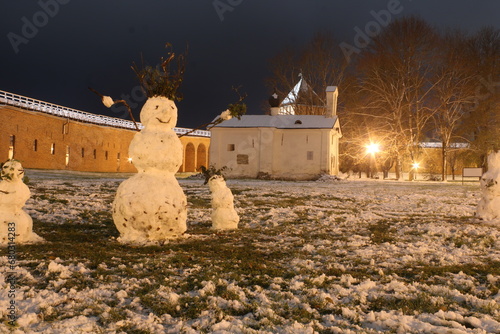 Funny snowmen at night and old castle and church