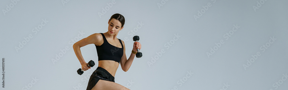 Woman doing cardio exercises with dumbbells on studio background . Healthy lifestyle Woman doing cardio exercises with dumbbells on studio background . Healthy lifestyle