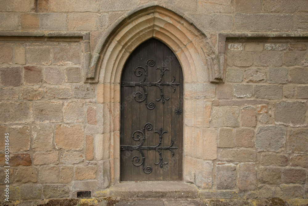 Ornamental arched doorway with black iron hinges Ornamental arched doorway with black iron hinges