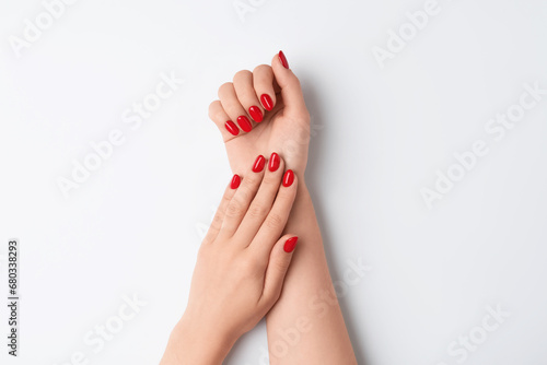 Woman with red polish on nails against white background, closeup