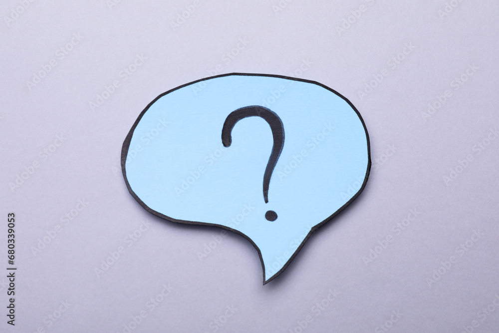 Paper speech bubble with question mark on light grey background, top view Paper speech bubble with question mark on light grey background, top view