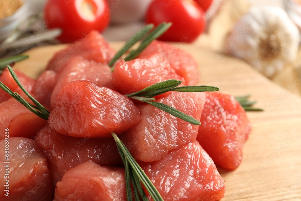 Cooking delicious goulash. Raw beef meat with rosemary on table, closeup