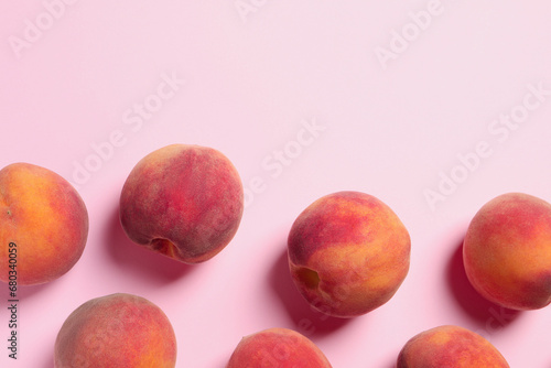 Many whole fresh ripe peaches on pink background, flat lay. Space for text