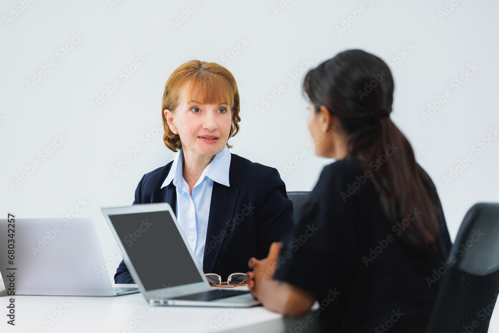 Mentor, coaching or business women with computer talking, speaking or planning a project in office. Technology, teamwork collaboration or senior manager explaining to an intern for digital training Mentor, coaching or business women with computer talking, speaking or planning a project in office. Technology, teamwork collaboration or senior manager explaining to an intern for digital training