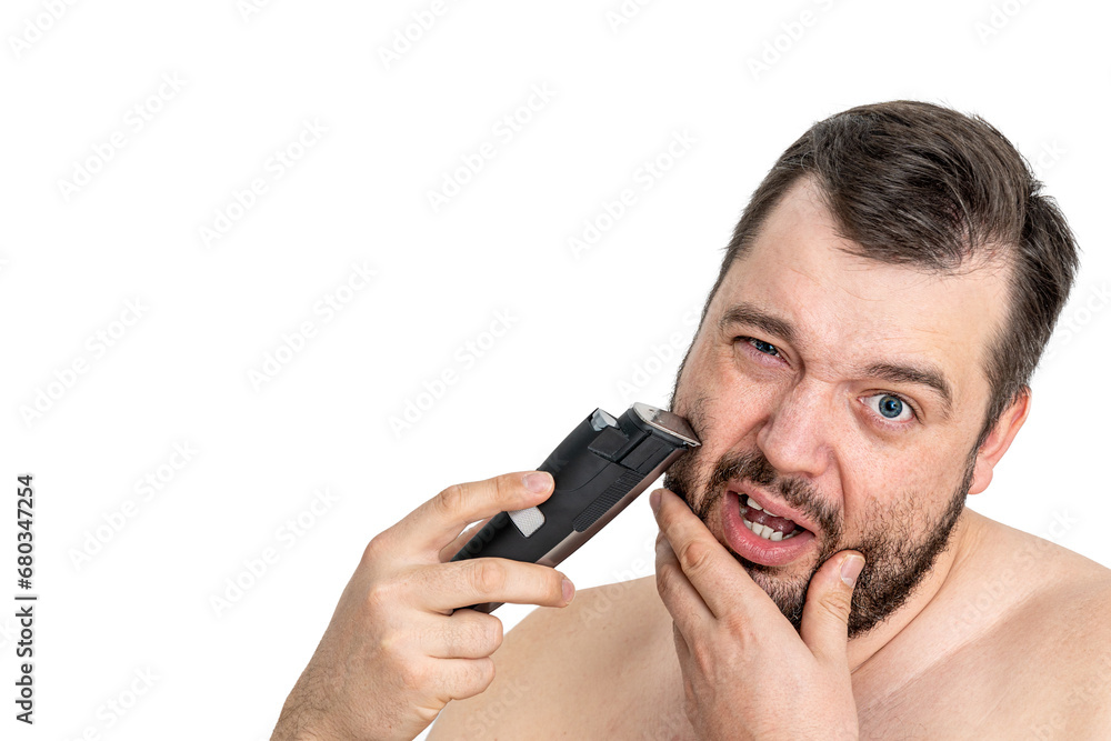 Isolated shot of a young man grooming with an electric razor on a white background. The man appears focused and the image reflects personal care and grooming. Isolated shot of a young man grooming with an electric razor on a white background. The man appears focused and the image reflects personal care and grooming.