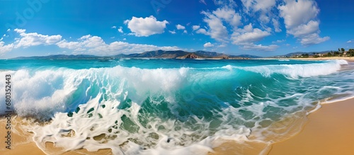 Fototapeta Naklejka Na Ścianę i Meble -  The breathtaking ocean waves, with their striking blue color, provide a stunning backdrop against the vibrant sky and golden beach, creating a picturesque summer landscape that highlights the beauty