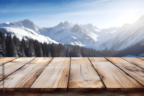 Wooden table with a snowy mountains and trees in the background for displaying purposes. High quality photo. © Sarah