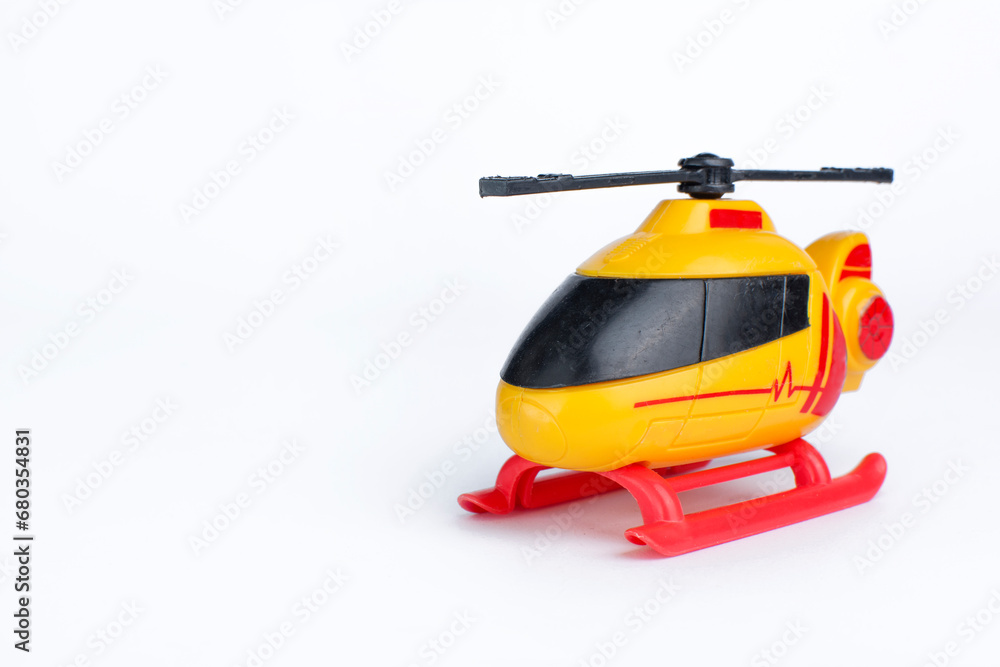 Yellow, red, and black helicopter toy on white background