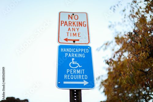 handicap parking sign in blue and white on a paved lot, symbolizing accessibility and inclusivity in urban spaces photo