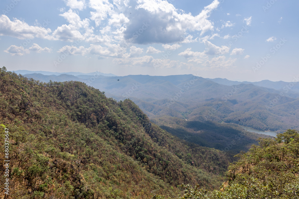 View to the hills from the slopes of Doi Nangmo mountain at mid day in February near Chiang Mai, Northern Thailand.