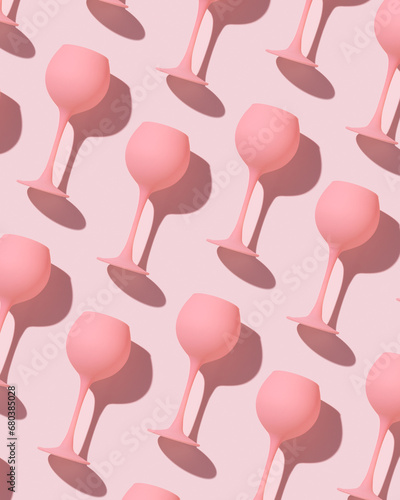 Photography Minimal trend pattern from pink colored wine glasses on pastel pink background, monochrome geometric stylish layout of goblets