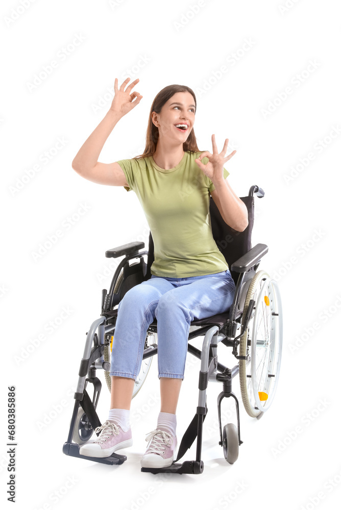 Young woman in wheelchair showing OK on white background Young woman in wheelchair showing OK on white background
