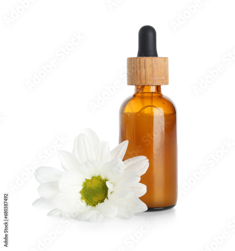 Bottle of essential oil with chamomile flower isolated on white background