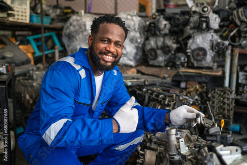 Portrait of man auto mechanic working at car repair shop with looking at camera.