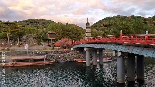 Asagiribashi Bridge in Uji, Kyoto. Crossing the River in the Evening. Beautiful traditional red japanese  bridge UNESCO World Heritage Site. Autumn in Japan photo