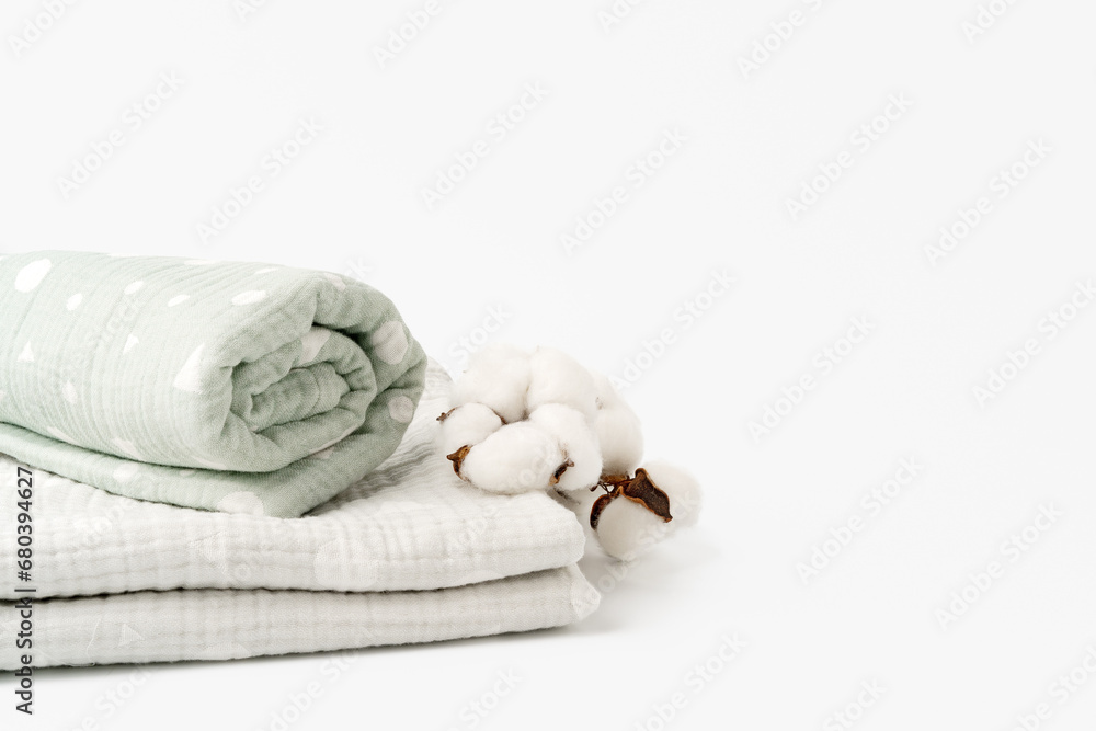 Muslin baby blankets with cotton flowers on white background Muslin baby blankets with cotton flowers on white background