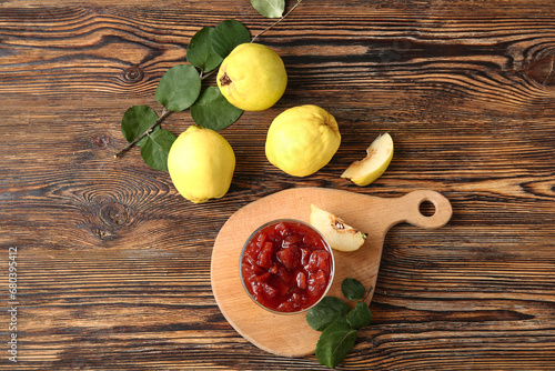 Fototapeta Naklejka Na Ścianę i Meble -  Bowl with jam and quince fruits on wooden background