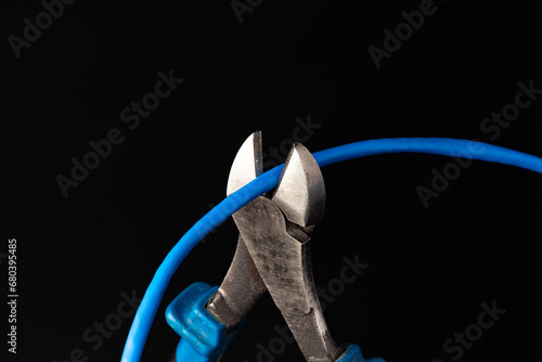 Cutting pliers cut electric cable close up photo