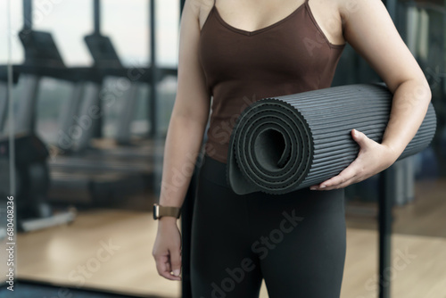 Sporty woman holding yoga mat for training yoga exercising fitness workout and health concept. training working out at gym.