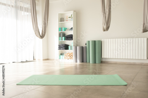 Gym interior with green yoga mat, big windows, no people. Copy space. photo