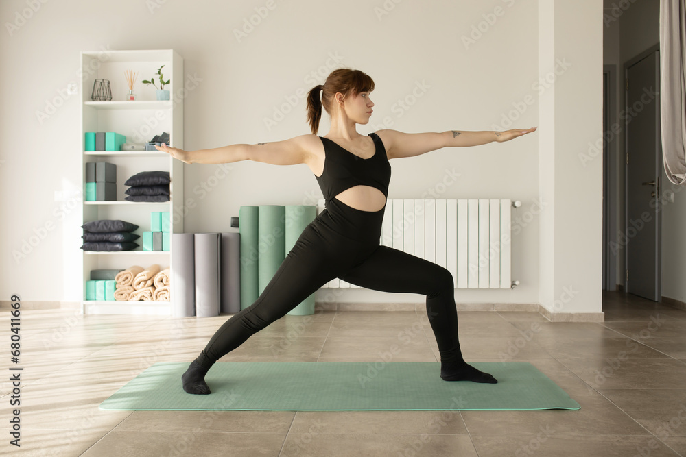 Woman practicing advanced yoga in fitness studio. 