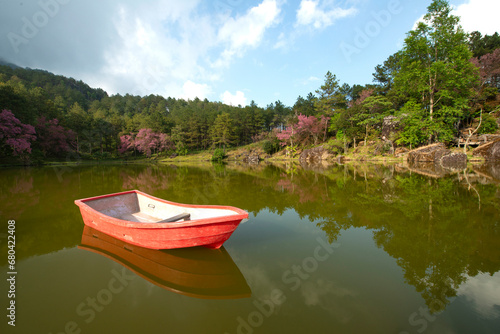 Beautiful scenery of a fishing boat on a lake with a reflection in the water © winai
