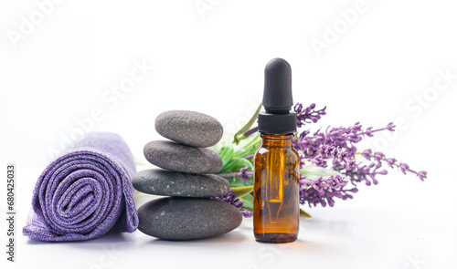 lavender aromatic oil in a glass bottle  lavender flowers and a pyramid of pebbles