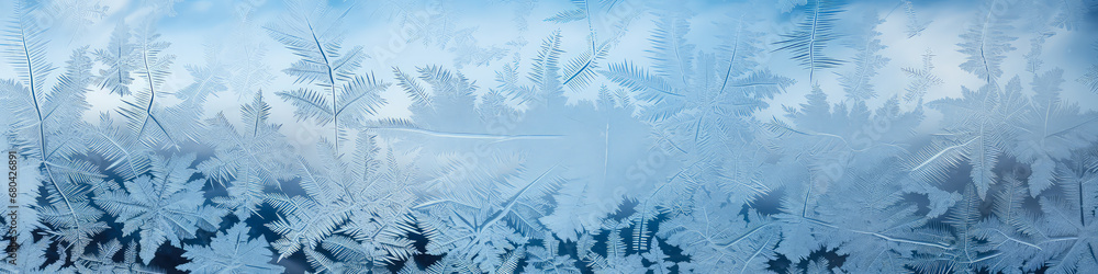 Frosty natural pattern on window glass. Frost pattern on the window. Snowflakes close-up. Winter background. Banner.