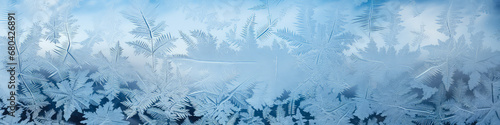 Frosty natural pattern on window glass. Frost pattern on the window. Snowflakes close-up. Winter background. Banner.
