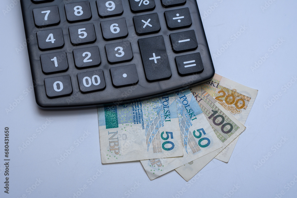 Kalkulator elektroniczny postawiony na polskich papierowych banknotach - obrazy, fototapety, plakaty 