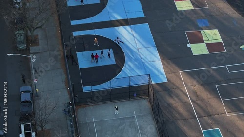 Aerial shot of unrecognizable teenagers playing pickup basketball in Bedford-Stuyvesant, Brooklyn on an autumn afternoon. photo