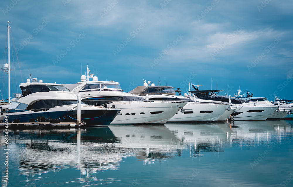 Fototapeta premium Many white modern yachts moored at the pier of marina.