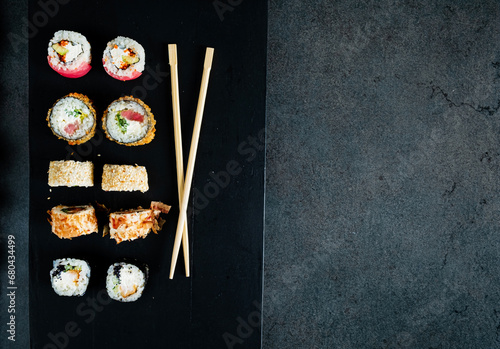 sushi with chopsticks on the dark background
