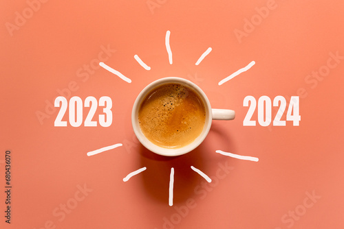 Happy new year and Merry Christmas 2024. Cup of coffee change and download 2023 to 2024 on orange background. Start up and New Year Concept. Copy space photo