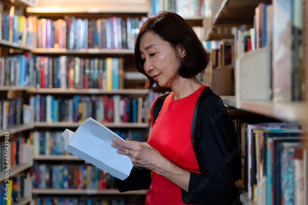 Senior woman reading books at old library downtown which has the old books. The library is open to the public for reading, education, relaxation, and searching ancient information. Senior woman reading books at old library downtown which has the old books. The library is open to the public for reading, education, relaxation, and searching ancient information.