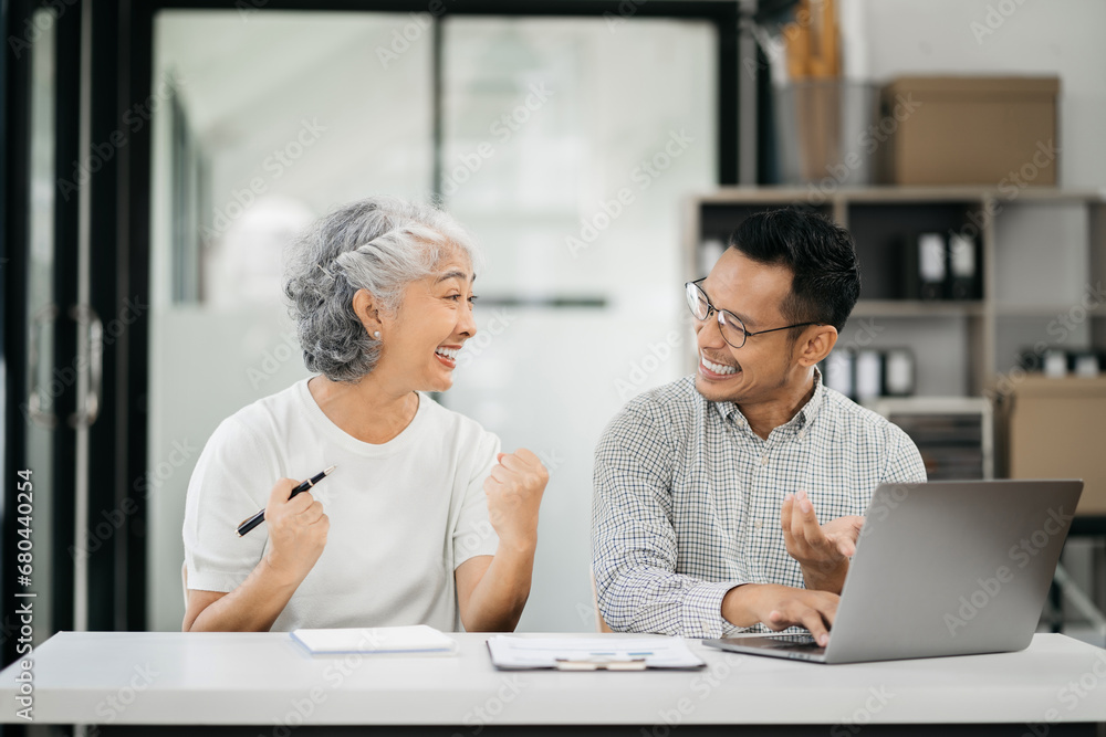 Fototapeta premium Happy business owners smiling at sales success after checking profits from home office online store, concept of online commerce and e-commerce.