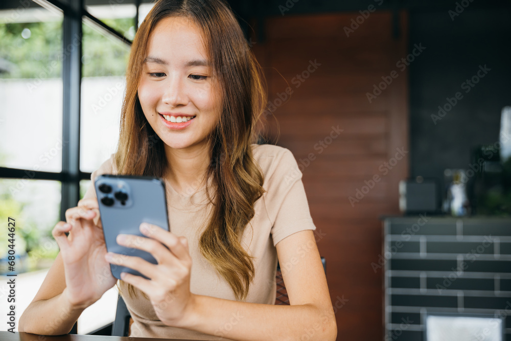 Beautiful Asian female has transfer money financial internet banking on mobile phone, young woman using smart phone for shopping online at cafe coffee shop near windows in the morning Beautiful Asian female has transfer money financial internet banking on mobile phone, young woman using smart phone for shopping online at cafe coffee shop near windows in the morning