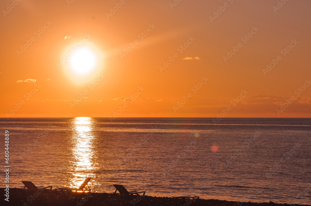 Sun loungers on the sea coast. Sea sunset.
