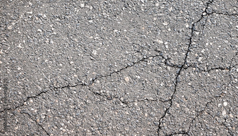 Obraz premium Gray asphalt with cracks as a background.