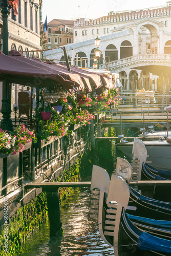 Rialto bridge with gondolas lined by restaurant terraces with flowers © Robert Ray
