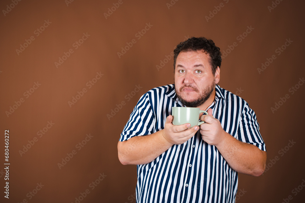 Early morning and various news. Funny fat man with a mug of coffee. Early morning and various news. Funny fat man with a mug of coffee.