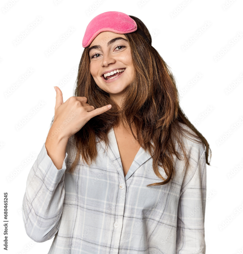Young Caucasian woman in pajamas with mask showing a mobile phone call gesture with fingers. Young Caucasian woman in pajamas with mask showing a mobile phone call gesture with fingers.
