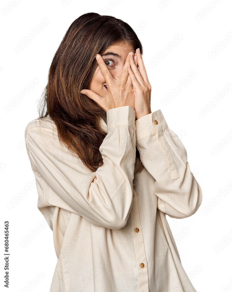 Young Caucasian woman in studio setting blink through fingers frightened and nervous. Young Caucasian woman in studio setting blink through fingers frightened and nervous.